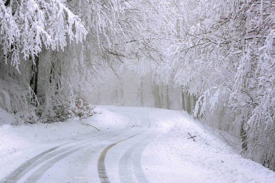 Vehículo circulando sobre una calzada con nieve